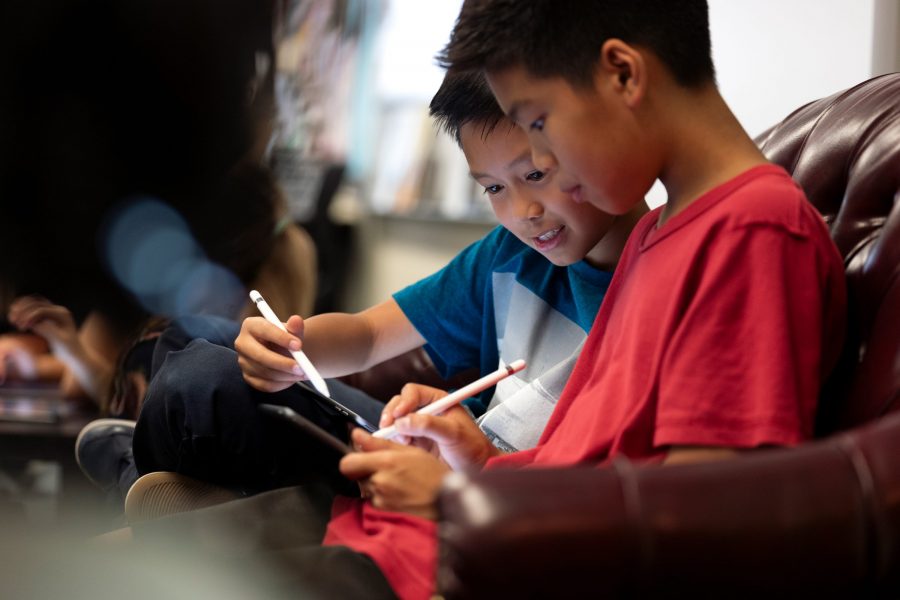 Two boys drawing with Apple Pencils.