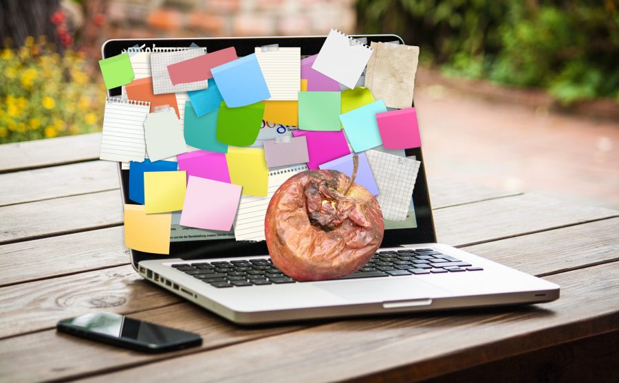 Photo of a MacBook with a rotten apple on top