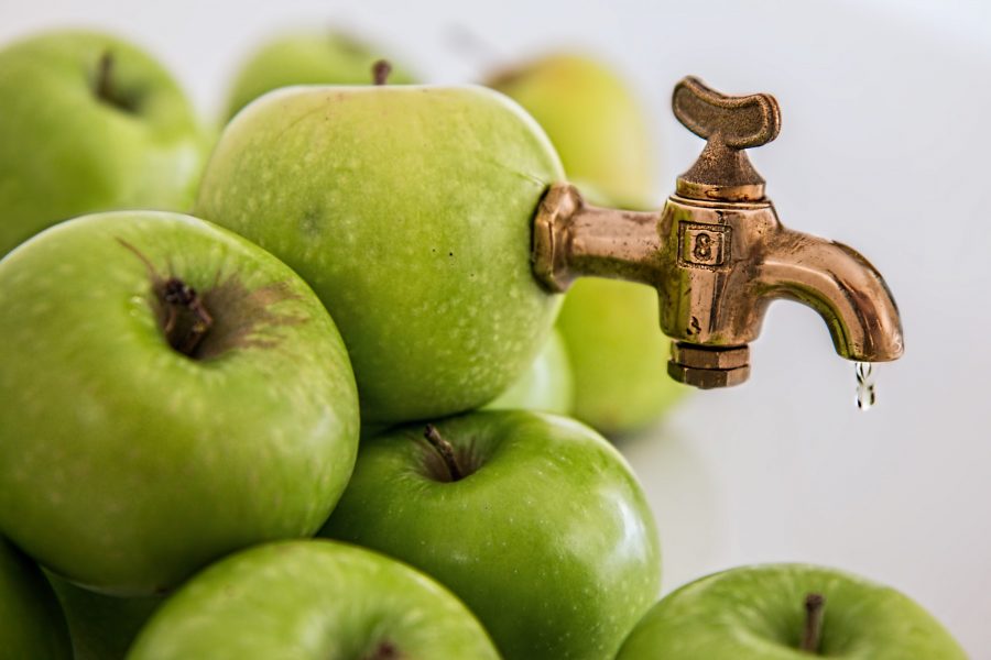 Photo of an apple with a faucet embedded in it, leaking