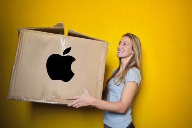 A lady carrying her Apple data in a cardboard box