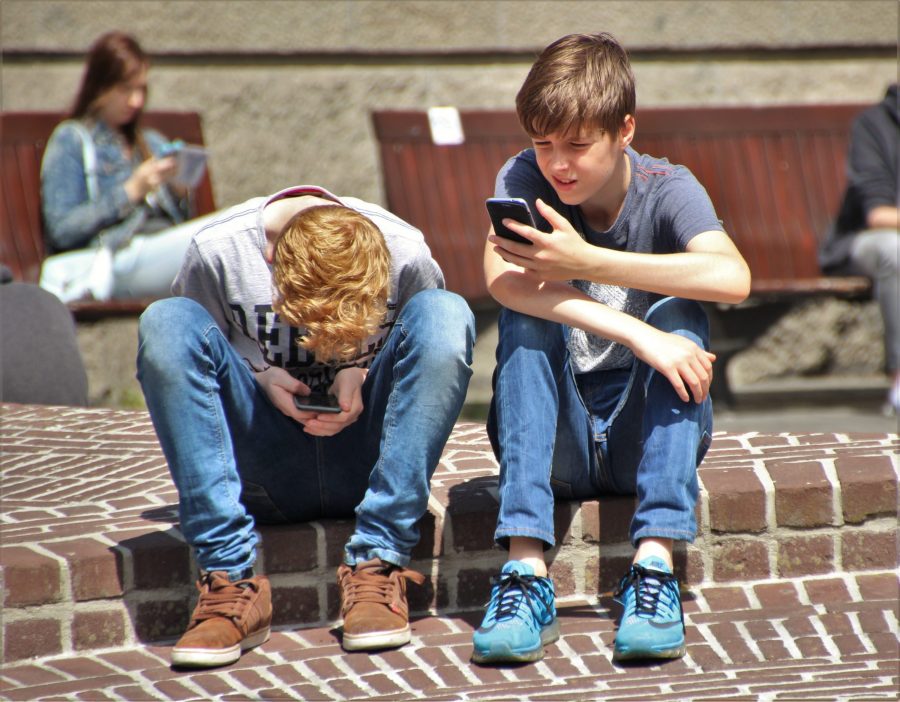 Boys looking at smartphones.