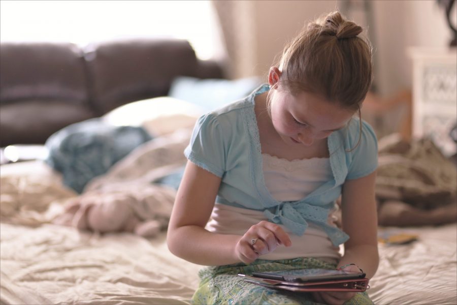 A girl playing with a tablet.