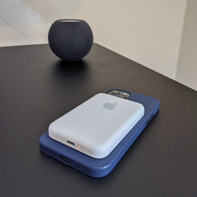 Een paarse iPhone met een MagSafe Battery Pack naast een HomePod mini