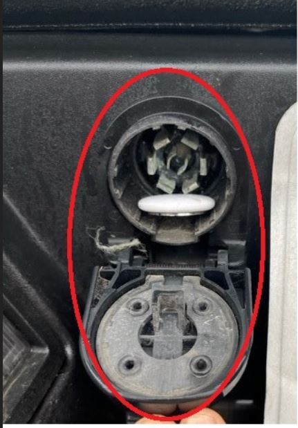 An AirTag hidden in an electrical adapter compartment